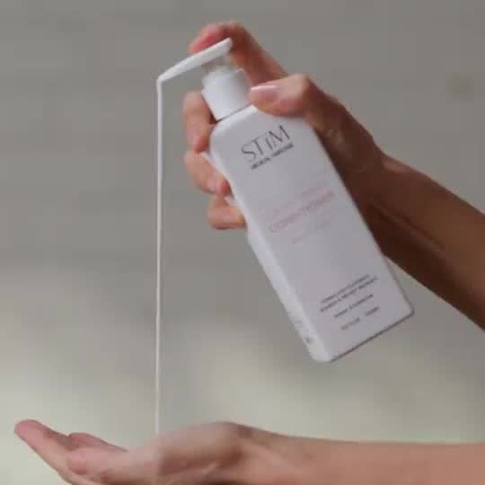 Hand dispensing Strengthening Conditioner from its pump bottle